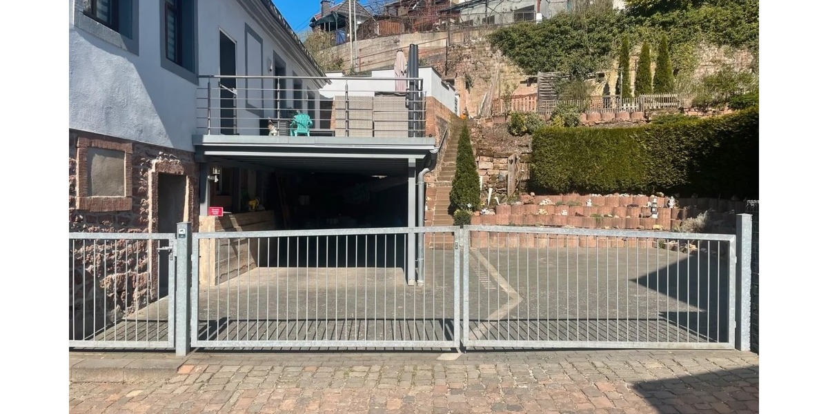 Straßenansicht mit Carport und Stellplätzen und Terrasse